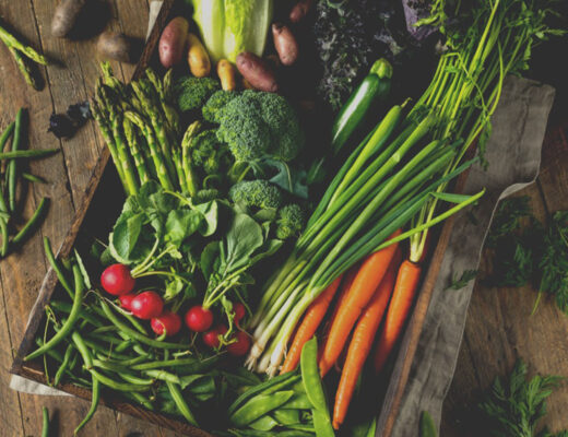 spring vegetables in basket on a wood table